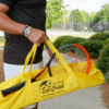 A man carrying a yellow Eye Coach tennis bag